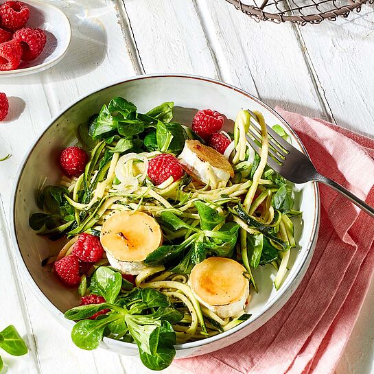 Scheiben von gratiniertem Chavroux, kombiniert mit Roter Bete und Feldsalat, werden auf einem Teller präsentiert.